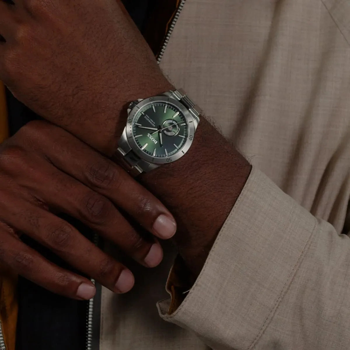 Hugo Boss Troper automatic watch on wrist displaying green dial and stainless steel case