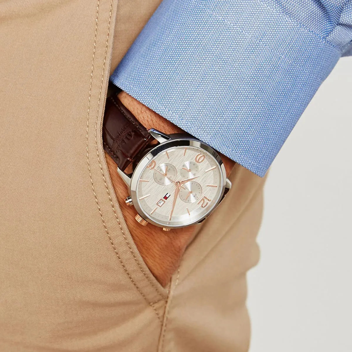 Tommy Hilfiger 1710360 chronograph watch worn on wrist with blue shirt and khaki jacket