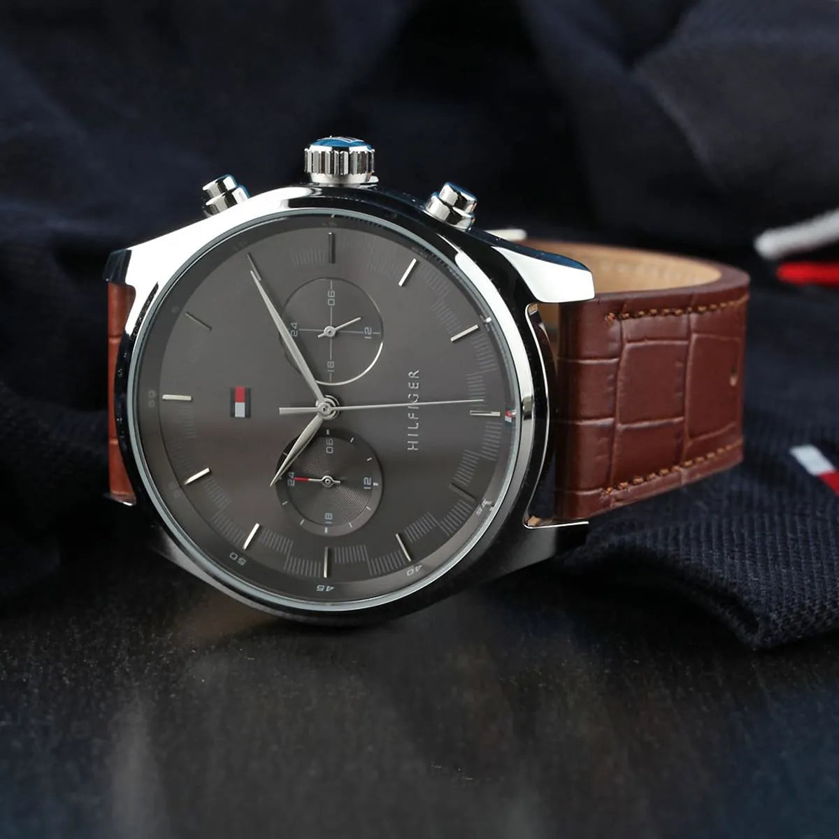 Tommy Hilfiger Sawyer watch on wrist with brown leather strap and gray chronograph dial