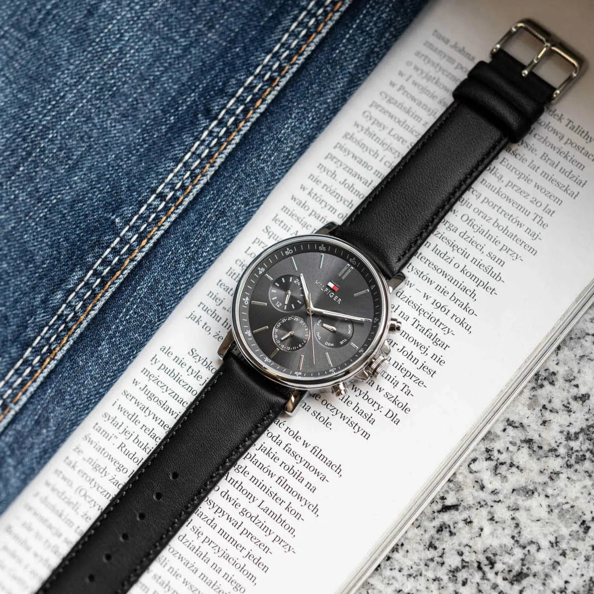 Tommy Hilfiger chronograph men's watch with black leather strap on newspaper background