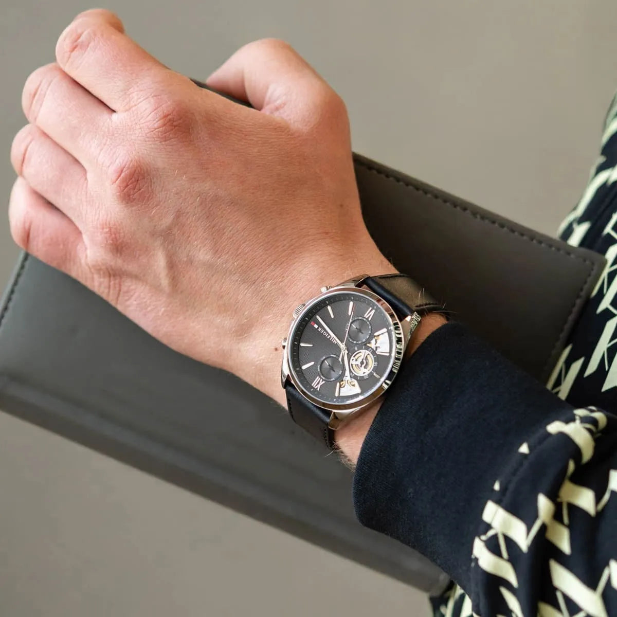 Tommy Hilfiger Damon watch worn on wrist, showing chronograph dial and black leather strap in casual wear