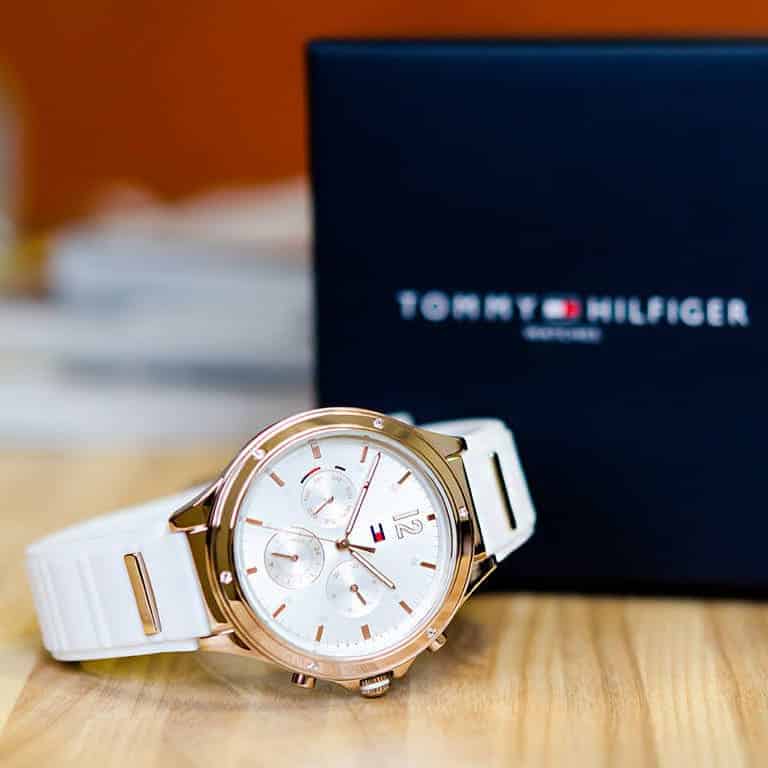 Tommy Hilfiger chronograph watch on wrist with white strap and packaging in background