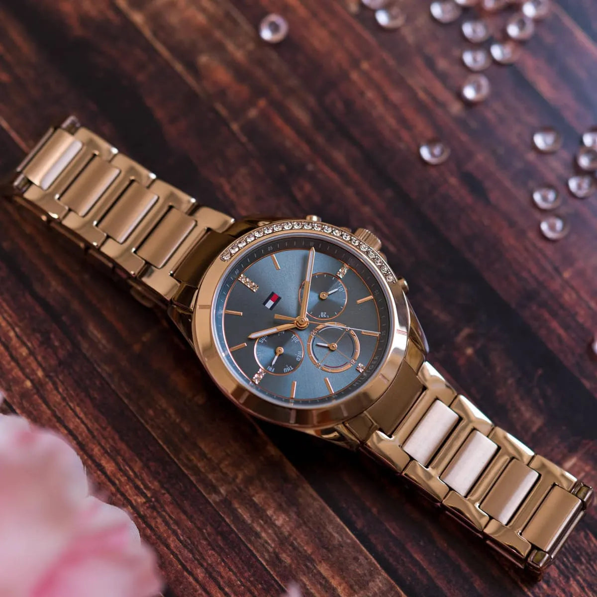 Tommy Hilfiger Kennedy women's watch styled on wrist with rose gold case and blue dial