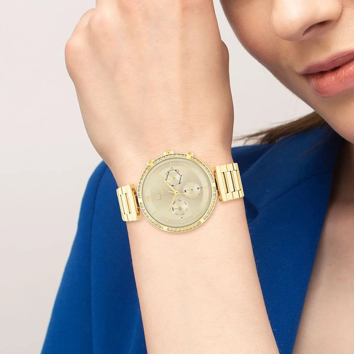 Tommy Hilfiger 1782392 gold-tone women's watch styled on wrist with blue top