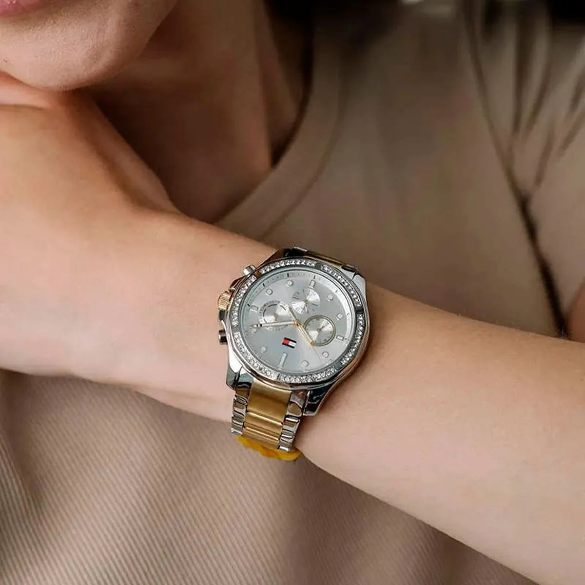 Tommy Hilfiger women's watch on wrist displaying two-tone metal bracelet and dial