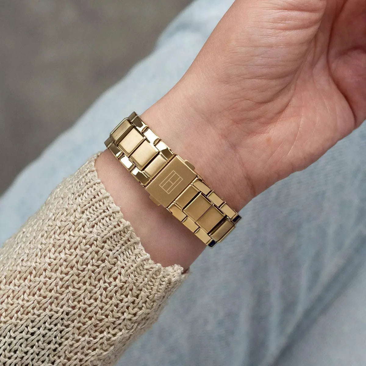 Close-up of gold stainless steel link bracelet detail on Tommy Hilfiger women's watch