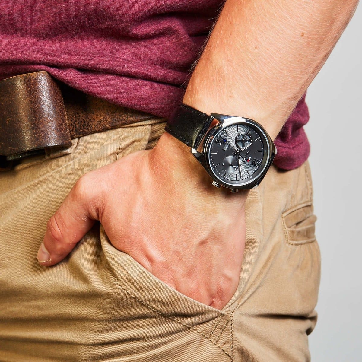 Tommy Hilfiger Deacan watch worn on wrist with burgundy and tan clothing