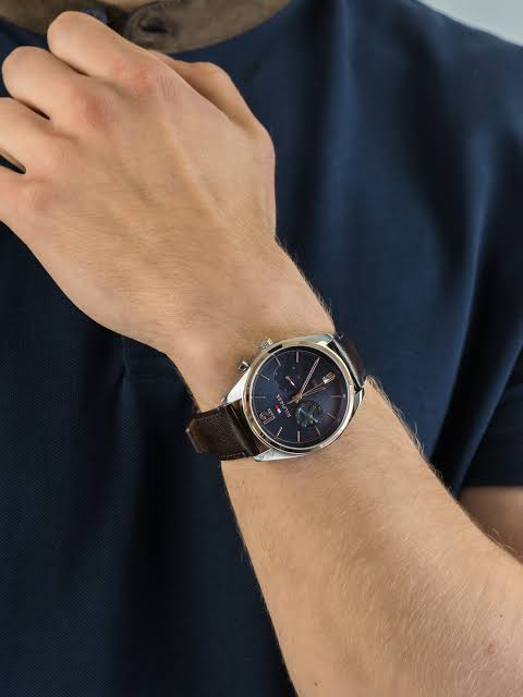 Tommy Hilfiger Deacan watch worn on wrist showing blue dial and brown leather strap