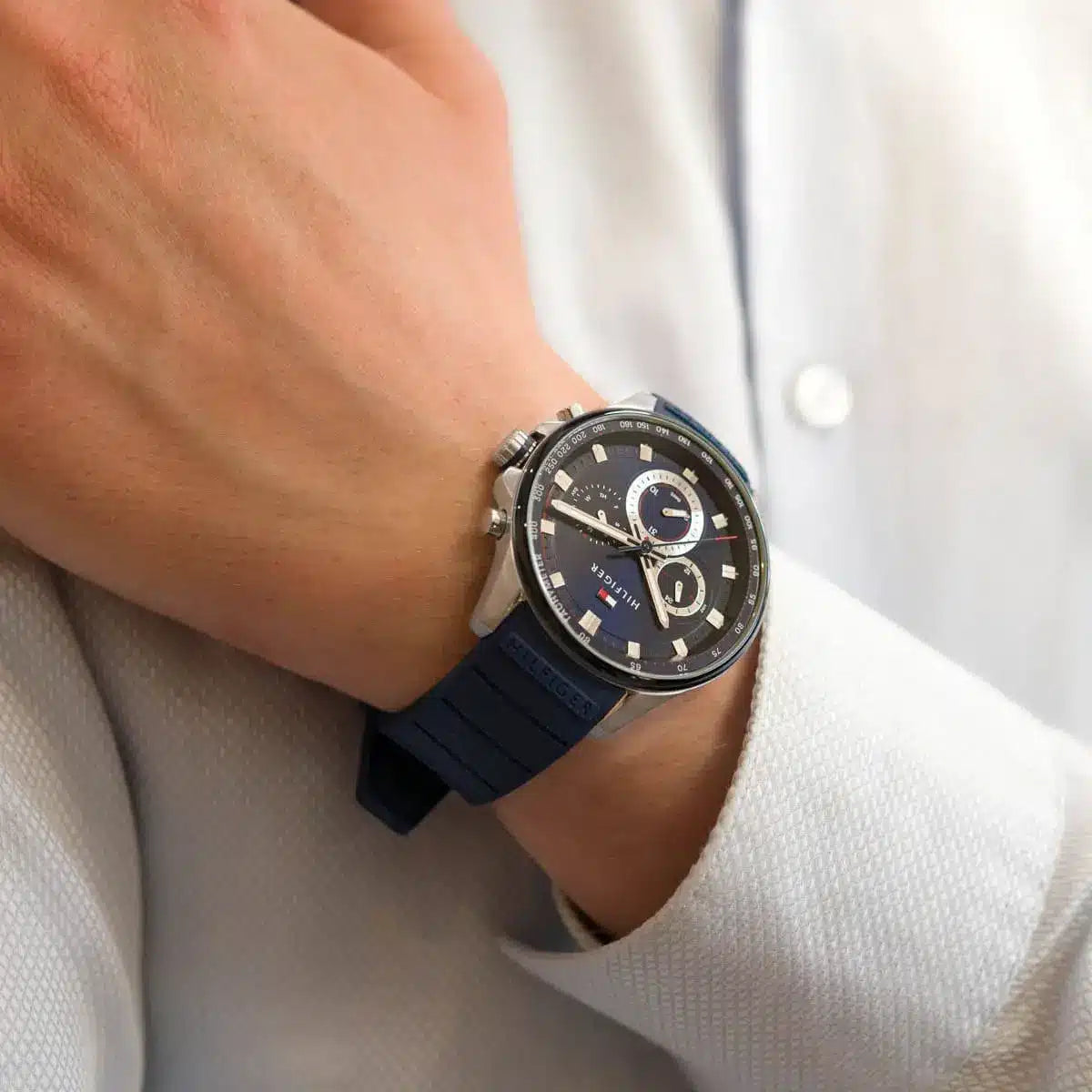 Tommy Hilfiger chronograph watch on wrist paired with white shirt sleeve