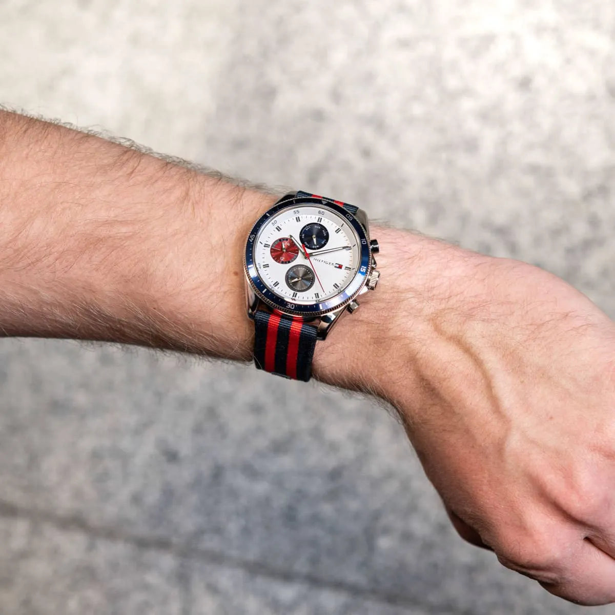 Tommy Hilfiger chronograph watch worn on wrist showing white dial and red sub-dial