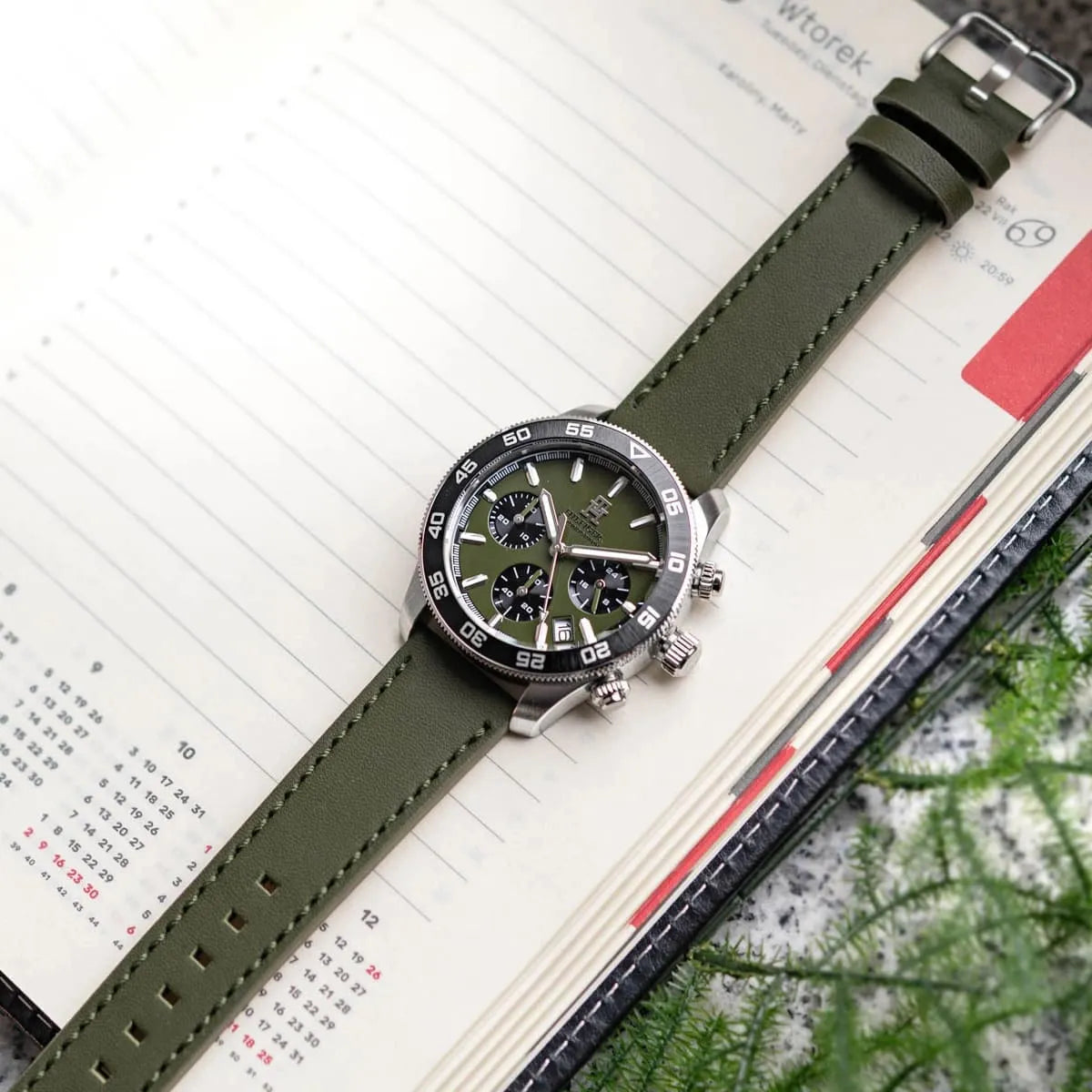 Tommy Hilfiger green chronograph watch on wrist with calendar open in background