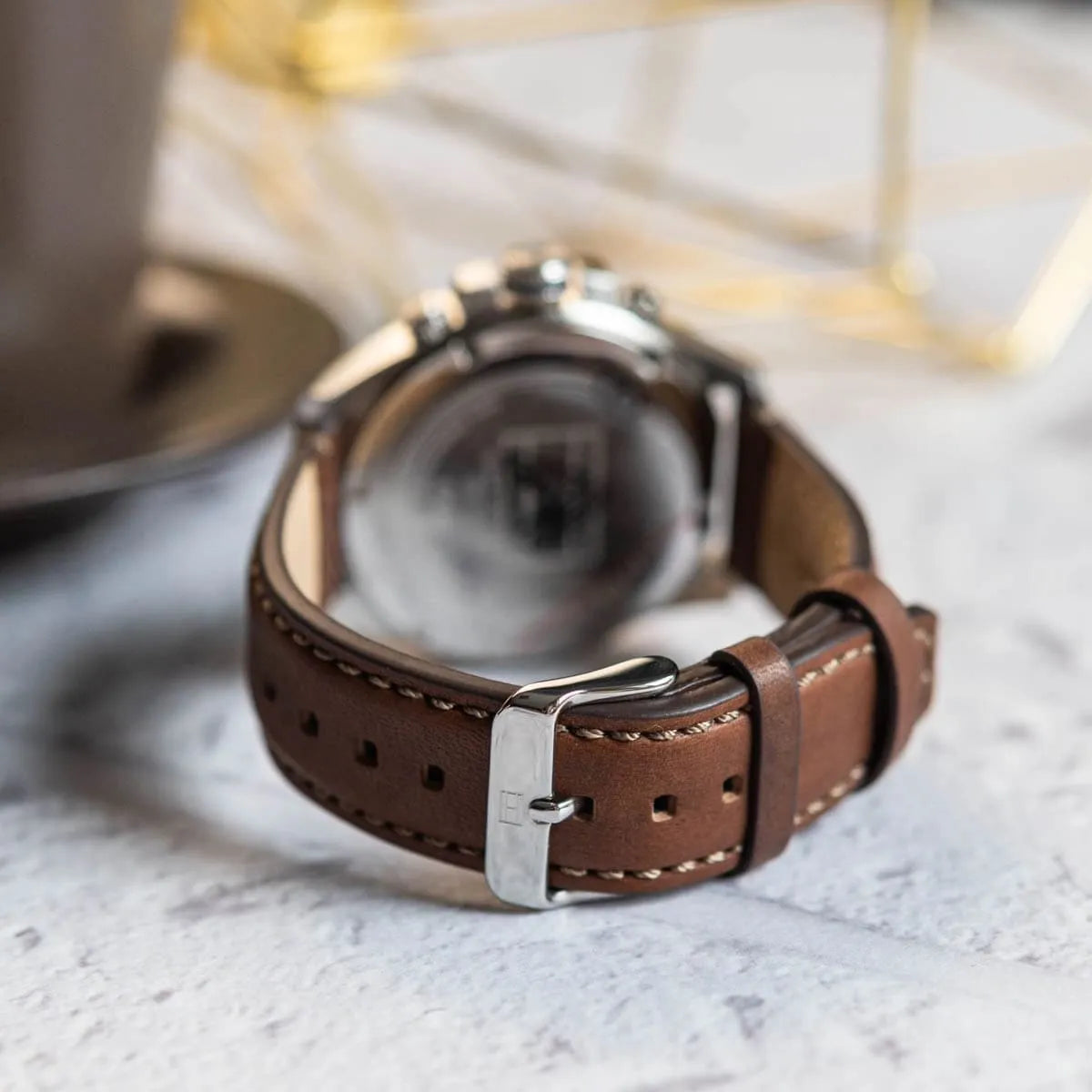 Tommy Hilfiger Jameson watch caseback detail showing white metal case and brown leather strap