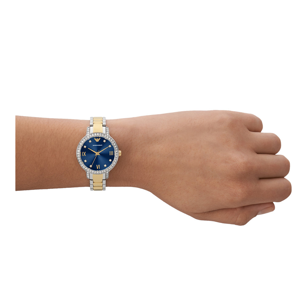 Emporio Armani Cleo women's watch worn on wrist, showing blue dial and two-tone steel and gold bracelet