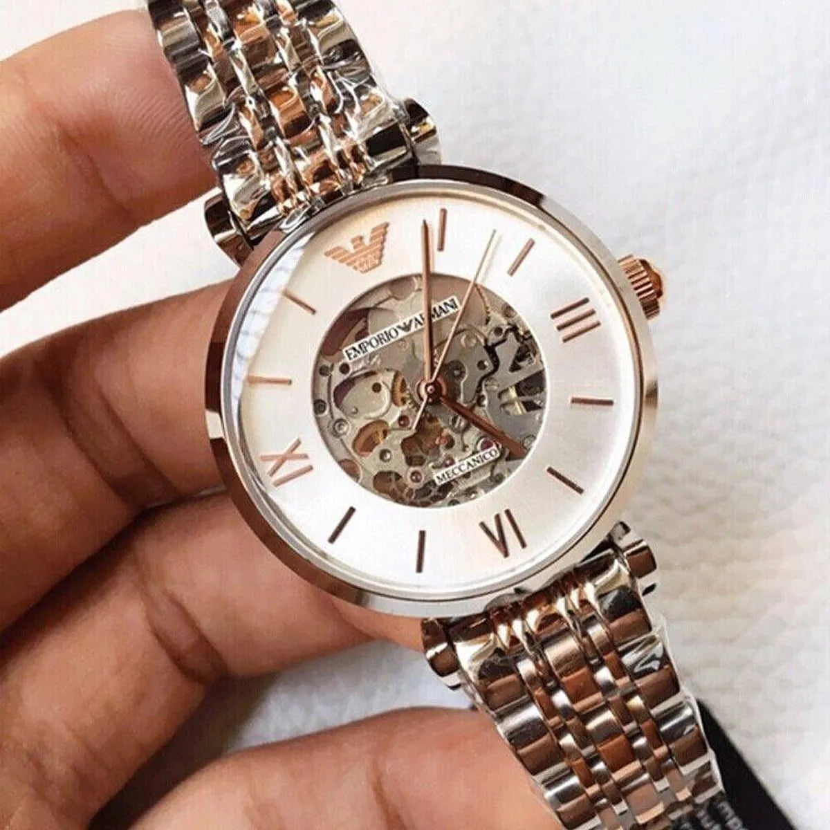 Emporio Armani AR1992 skeleton watch on wrist showing silver dial with rose gold accents and two-tone bracelet