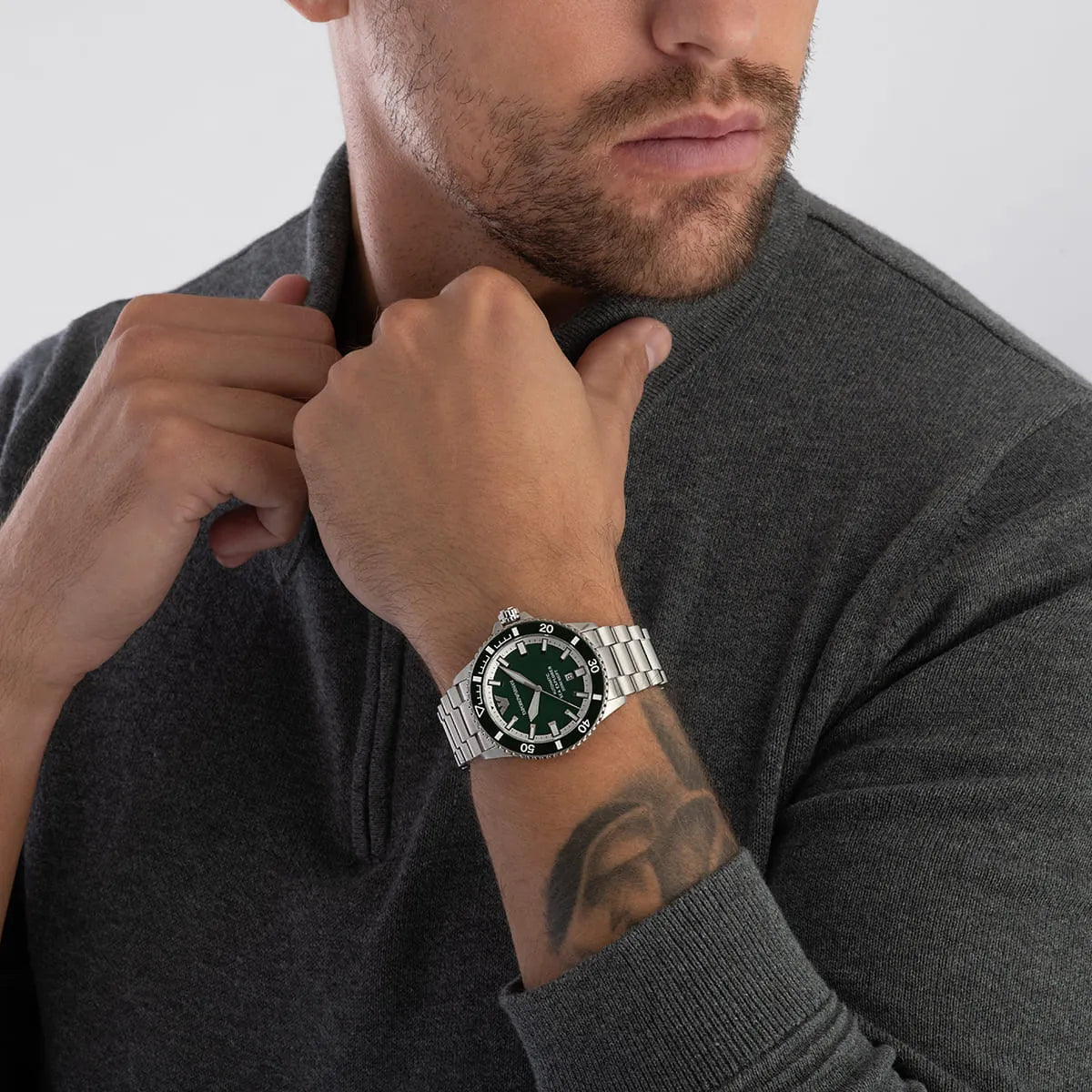 Emporio Armani Sea Explorer automatic watch worn on man's wrist showing green bezel