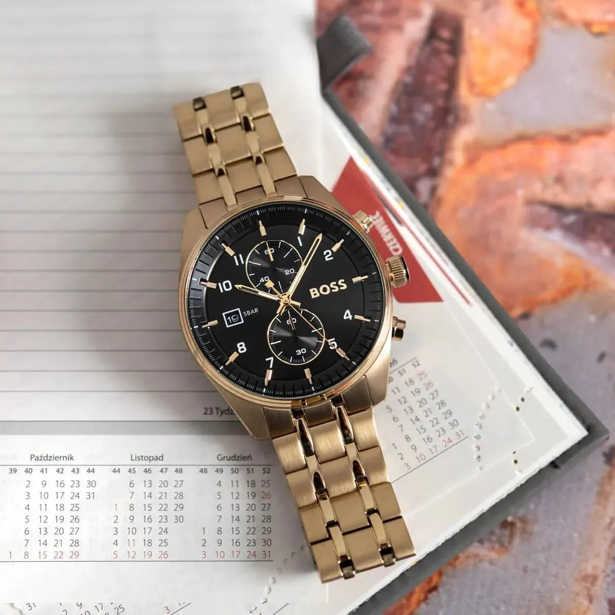 BOSS Ambassador chronograph watch displayed on black case with calendar visible