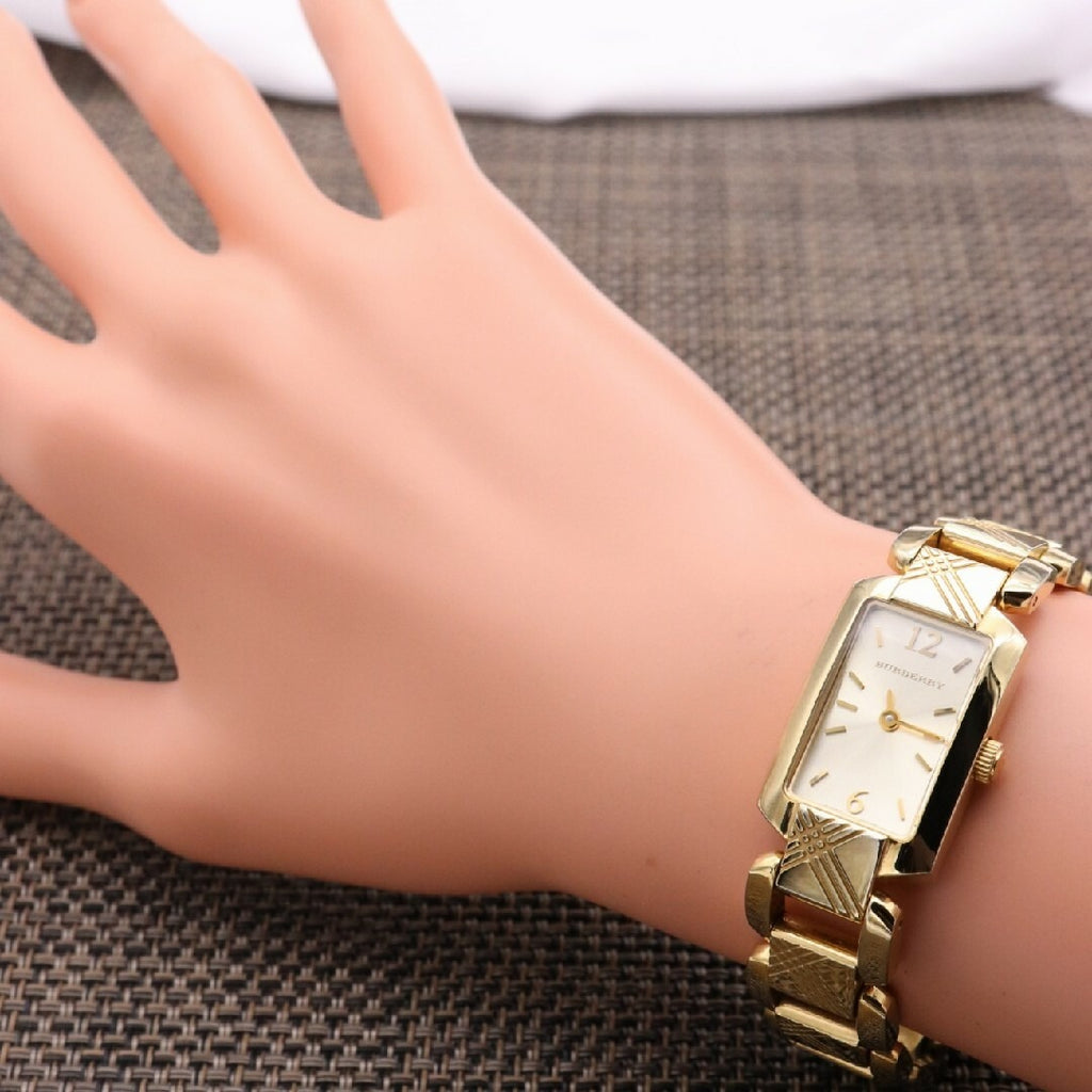 Burberry Heritage BU4213 women's watch worn on wrist with gold bracelet and silver dial