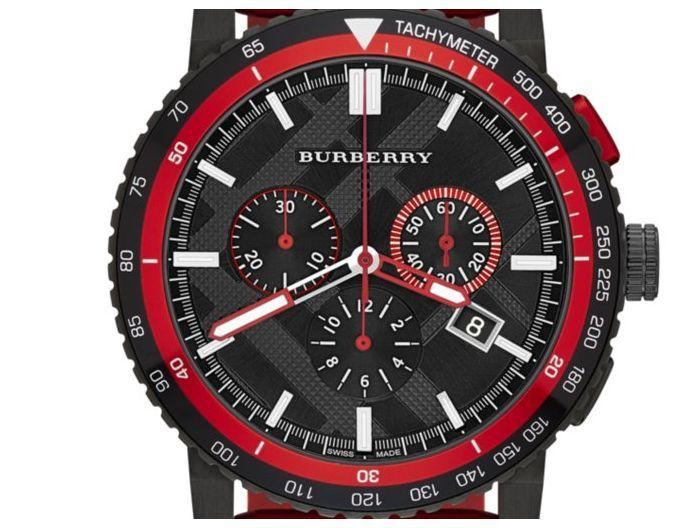 Close-up of black dial with chronograph subdials, white hour markers, and tachymeter scale