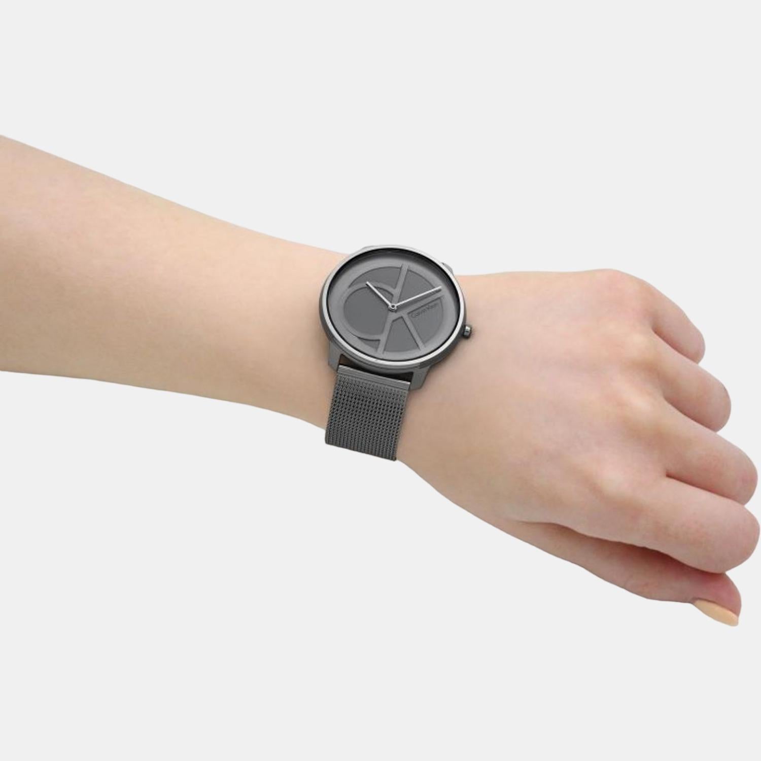 Calvin Klein watch on wrist showing grey sunburst dial and gunmetal mesh
