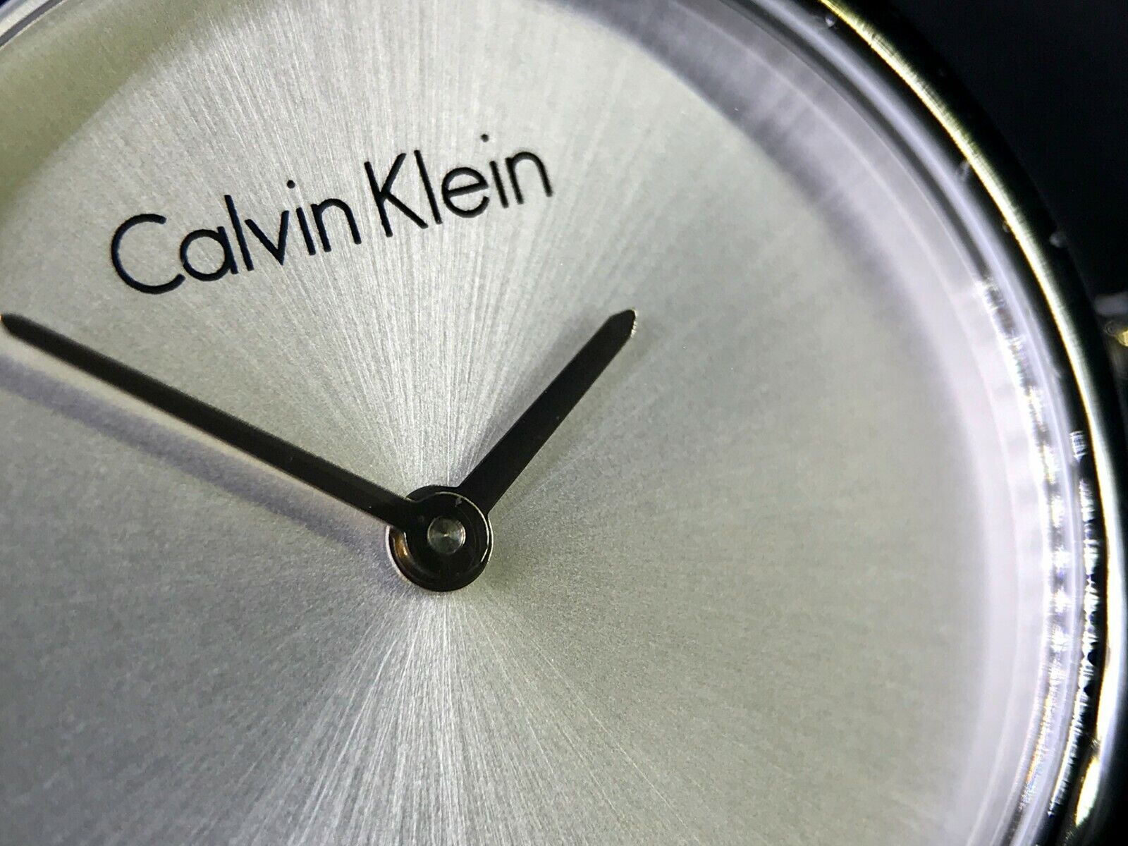 Close-up of Calvin Klein Authentic dial with logo, hour markers, and minimalist hands