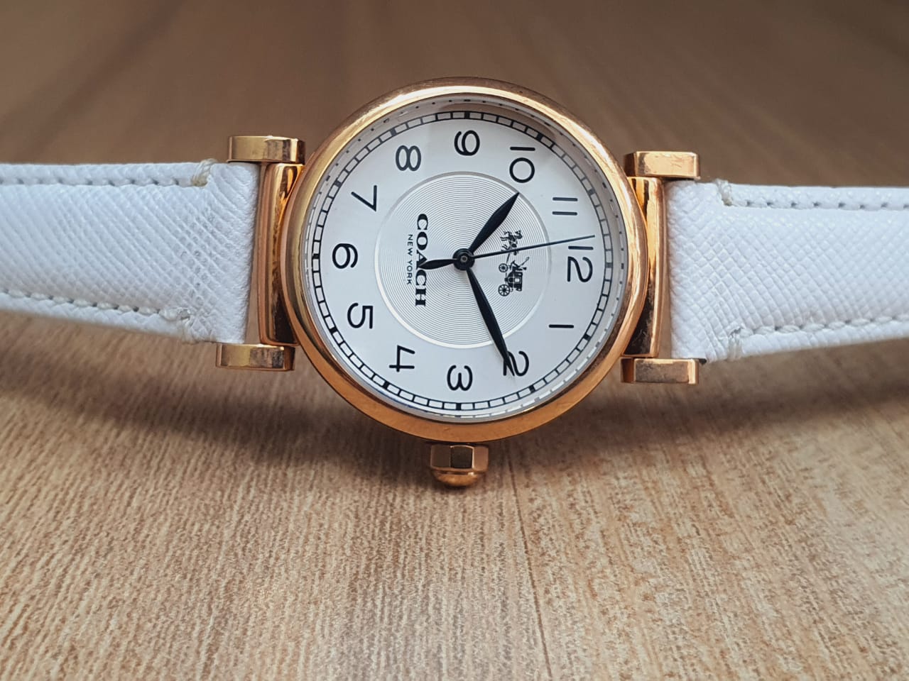 Coach Madison watch displayed on-wrist with white leather strap