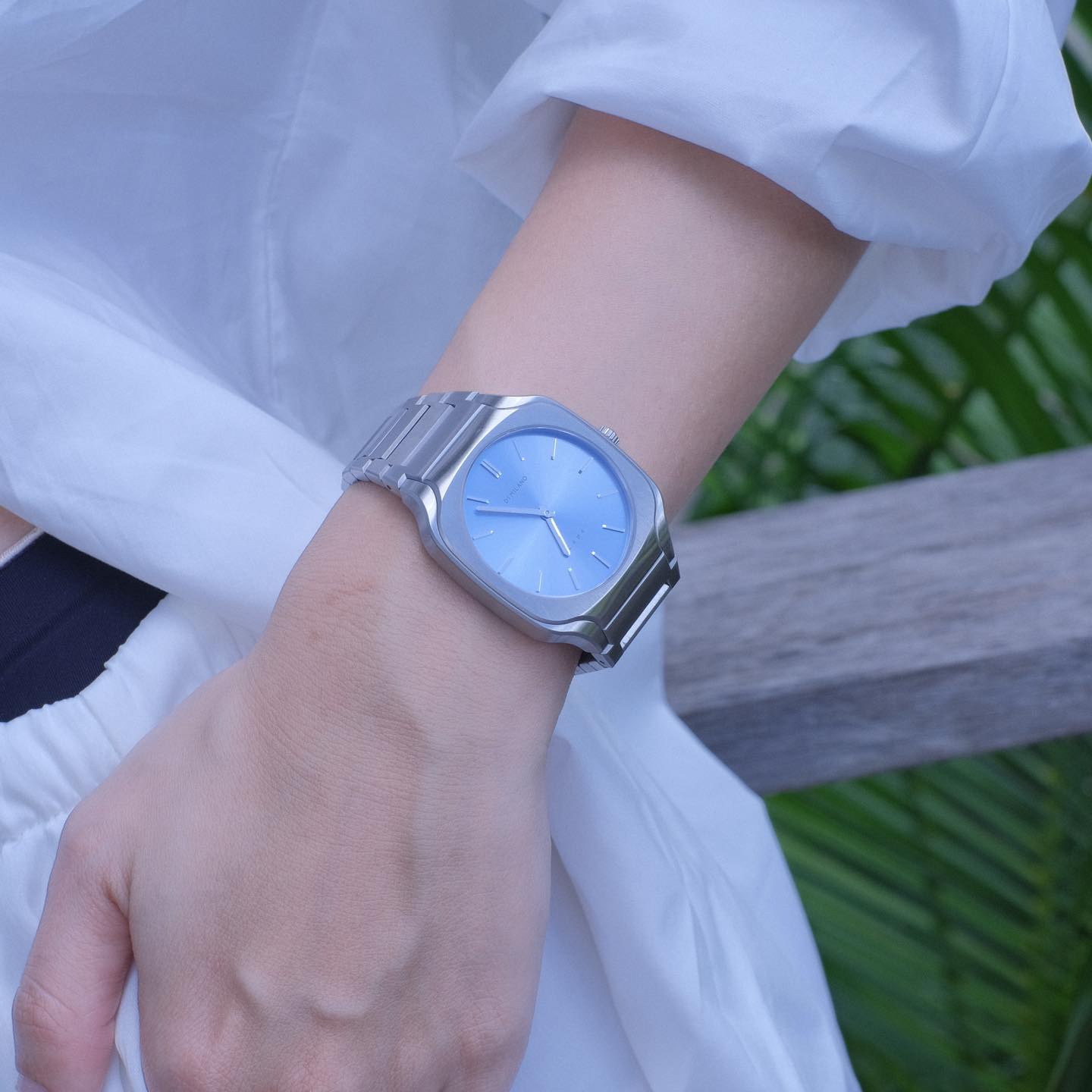 D1 Milano Square Maldives watch on wrist with silver strap and blue dial, outdoor setting