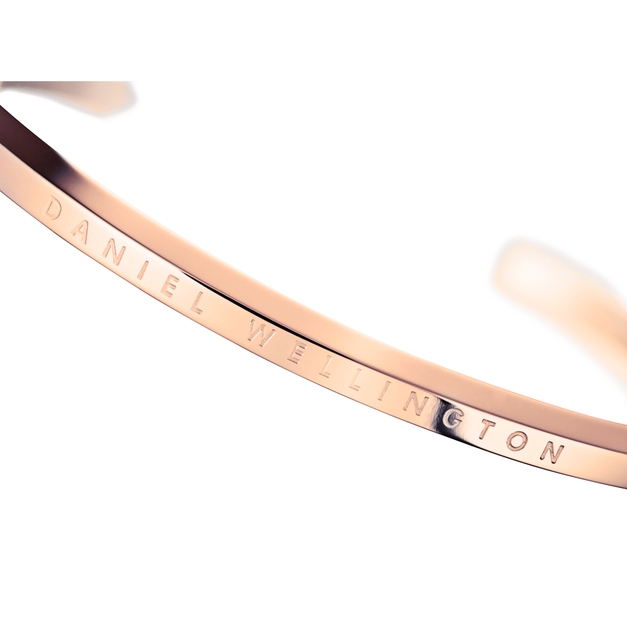 Close-up detail of rose gold bracelet showing Daniel Wellington engraved text along the interior surface
