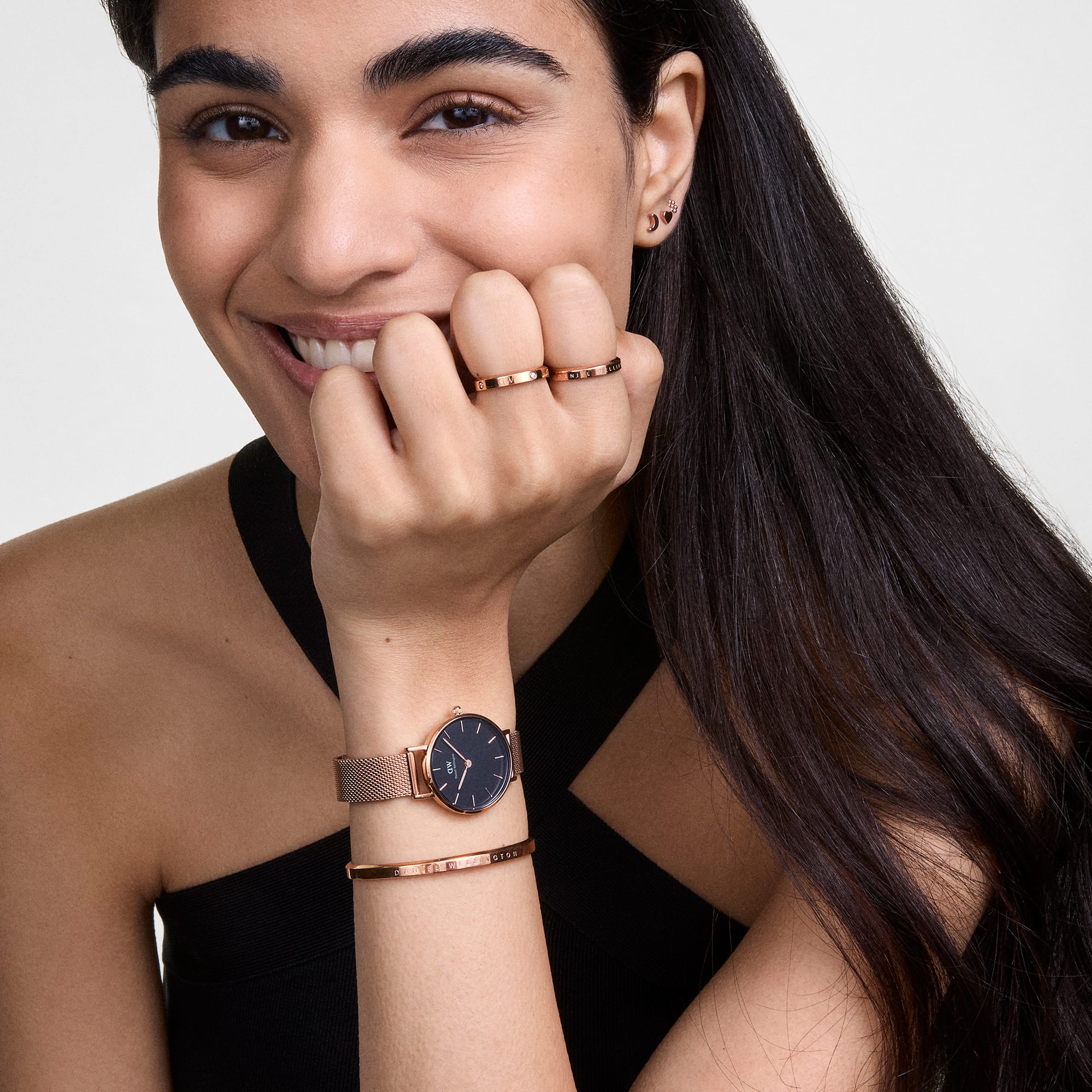 Rose gold bracelet worn on wrist paired with a Daniel Wellington watch and another rose gold bracelet