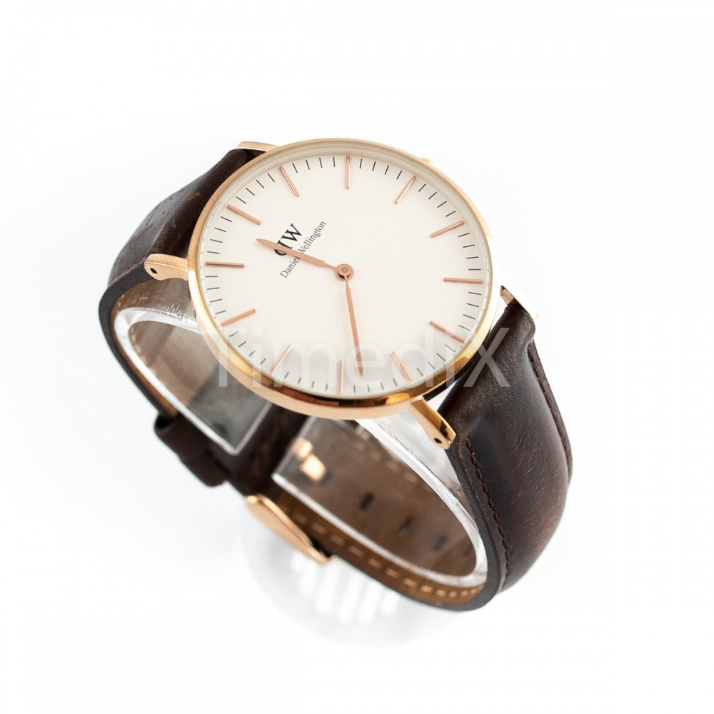Side view of Daniel Wellington Classic Bristol watch on wrist showing gold case profile and dark brown leather band