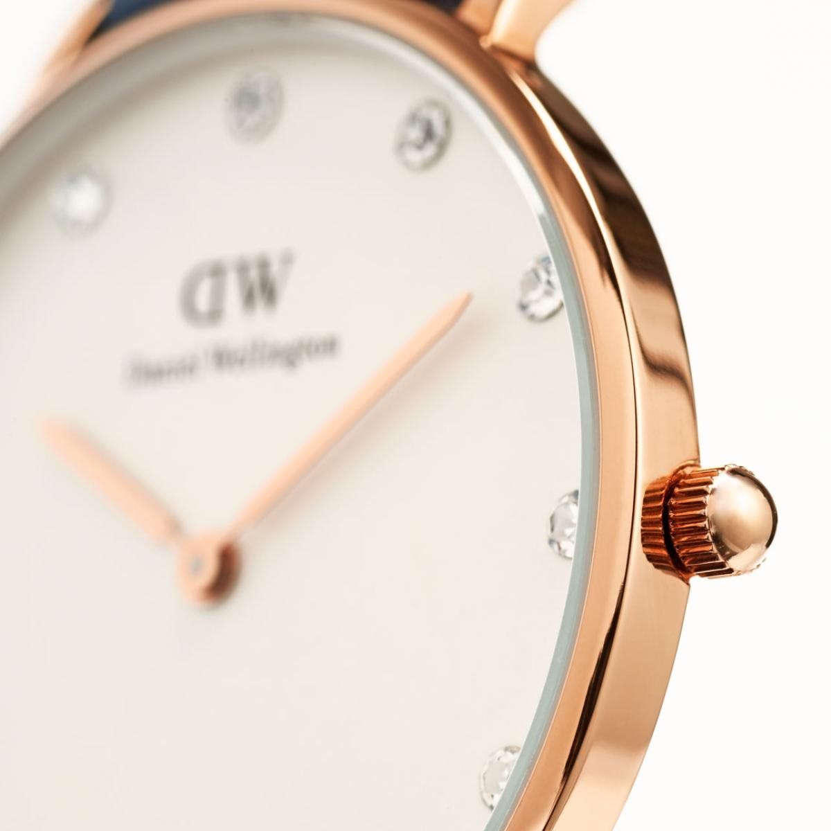 Close-up detail of dial showing rose gold crown and white face with hour markers