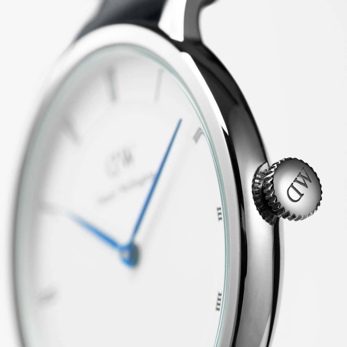Close-up of Dapper St Mawes dial and crown with Roman numerals and blue hands