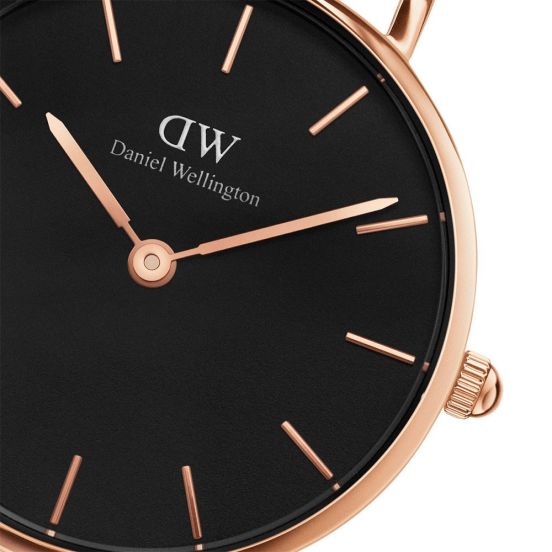 Close-up of black dial with rose gold hour markers and hands, Daniel Wellington branding