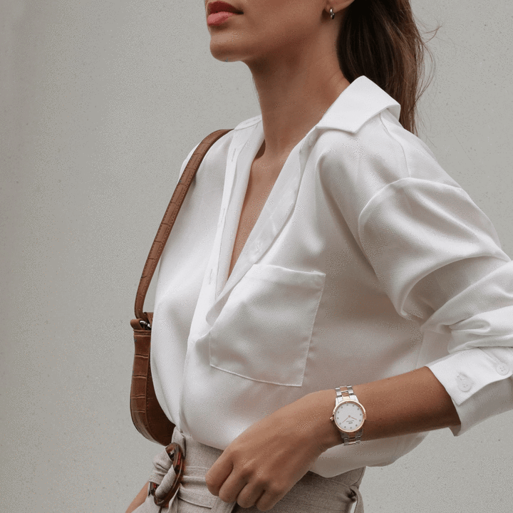 Two-tone ladies watch worn on wrist with white blazer, showing side profile