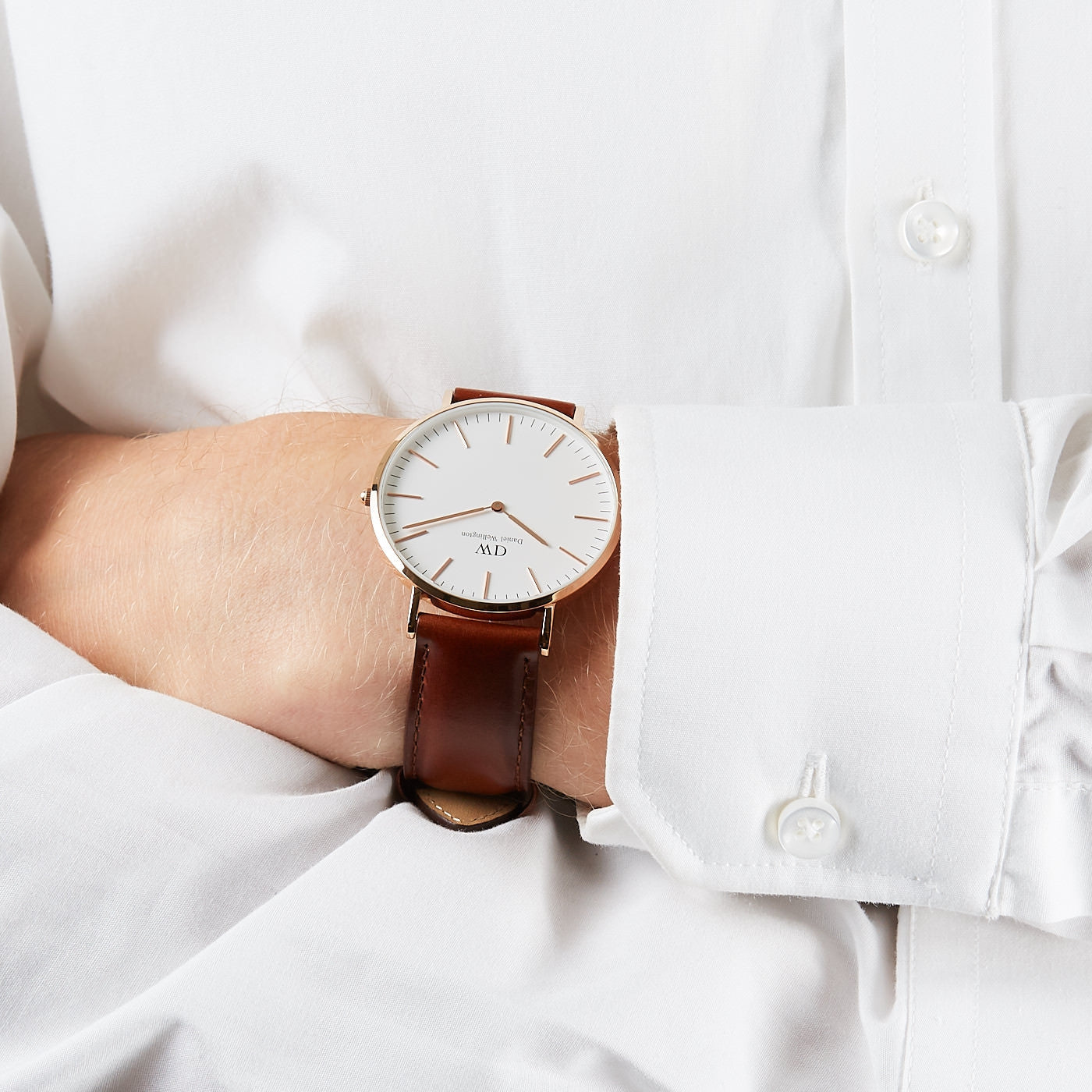 St Mawes 40mm watch on wrist showing rose gold case and brown leather strap against white shirt