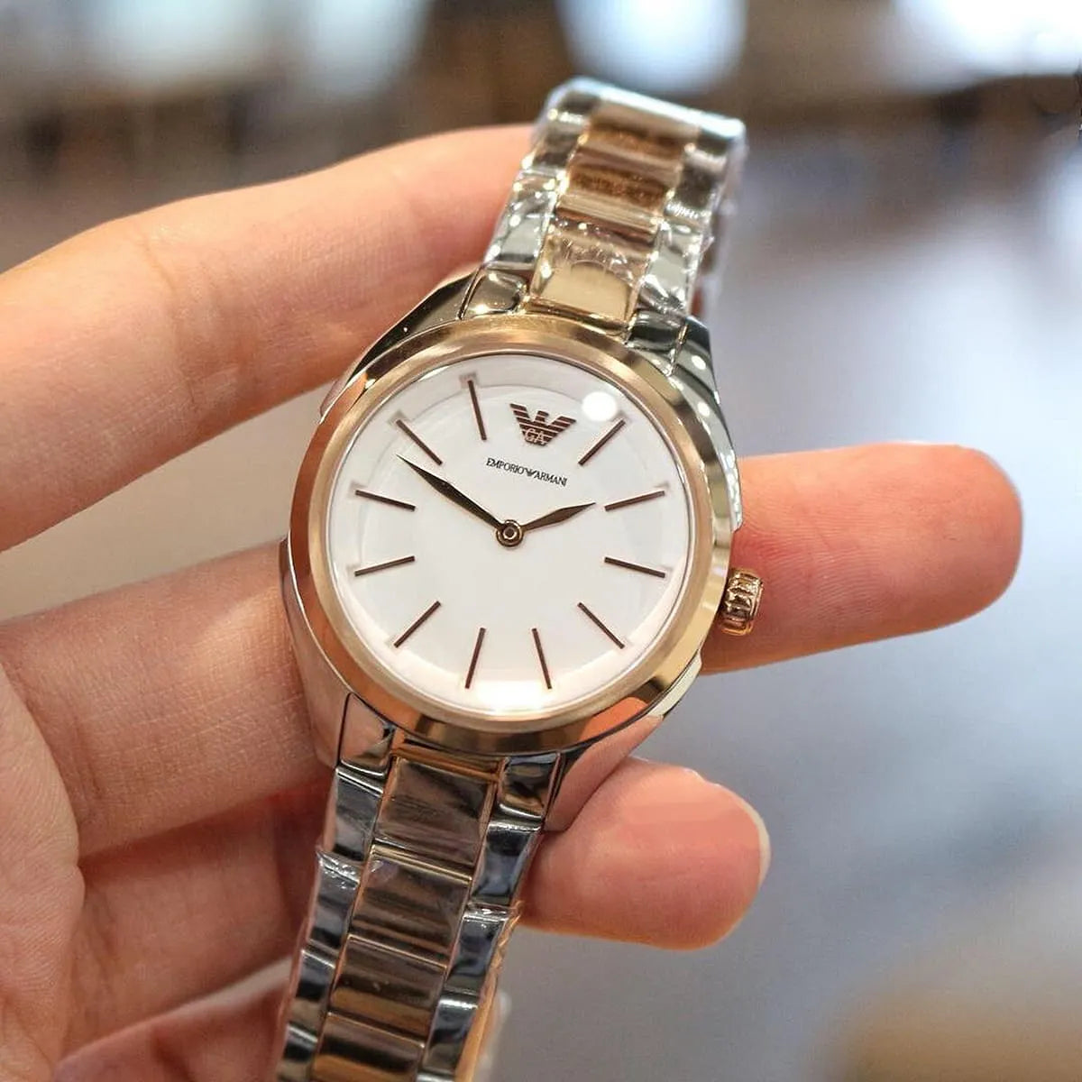Emporio Armani AR11029 two-tone watch worn on wrist showing white dial and rose gold accents