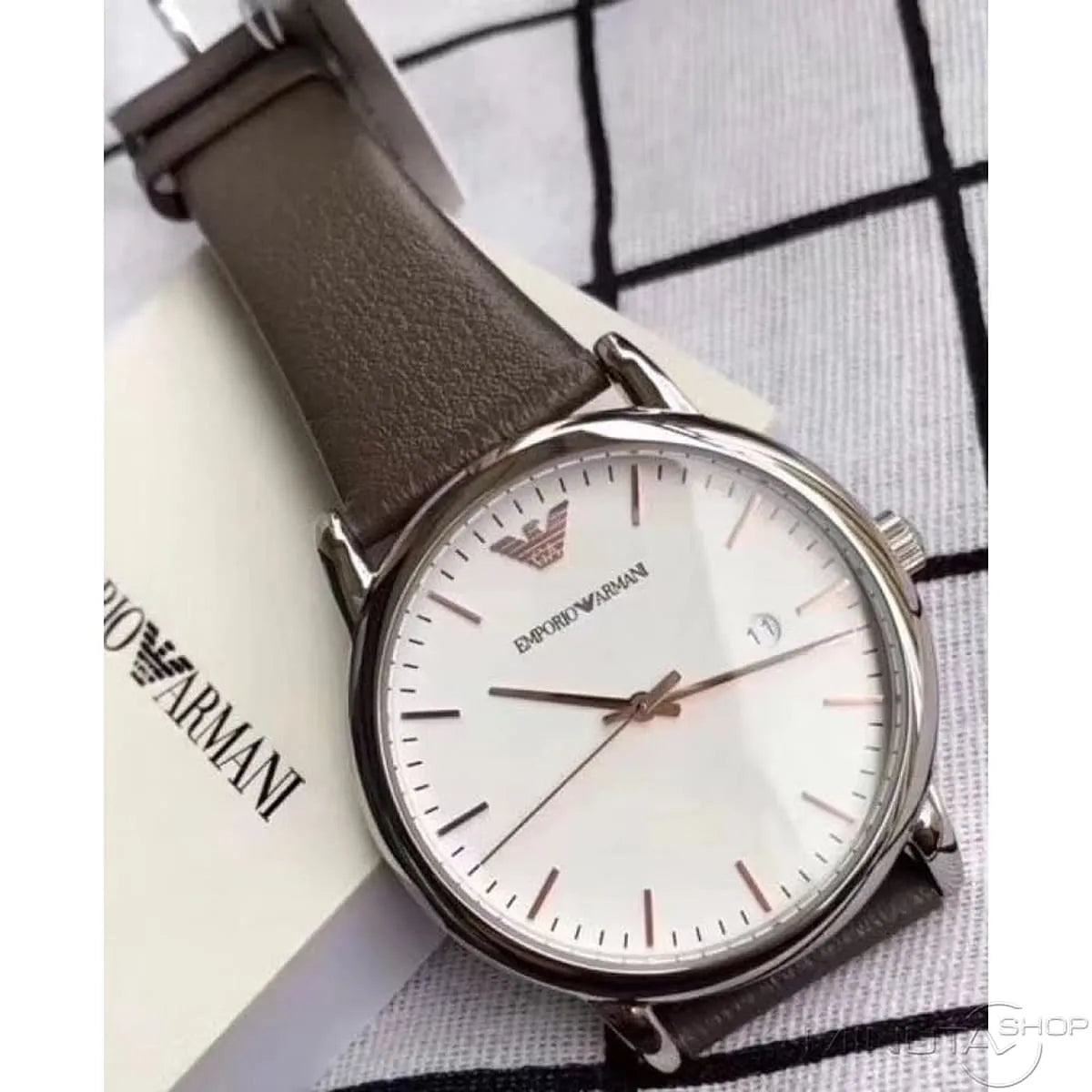 Emporio Armani Kappa watch displayed on branded packaging showing white dial and brown leather strap