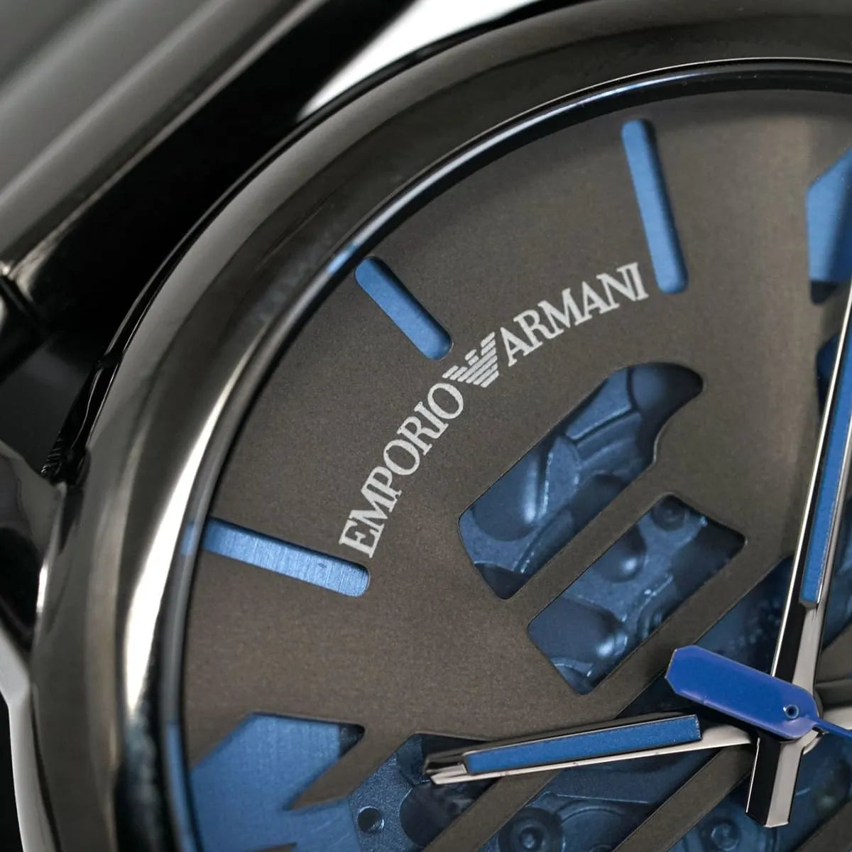 Close-up dial detail of Emporio Armani Meccanico with logo, blue indices, and mechanical rotor