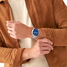 Fossil BQ2751 blue dial watch worn on wrist with brown leather jacket
