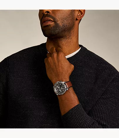 Fossil Bronson chronograph watch worn on wrist with brown leather strap against navy sweater