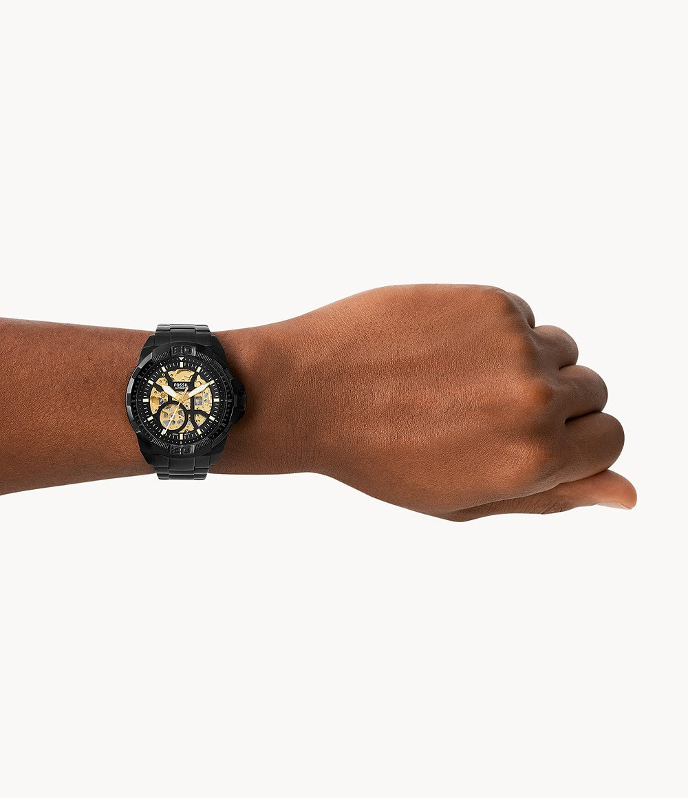 Fossil Bronson watch worn on wrist showing black case and bracelet with skeleton dial