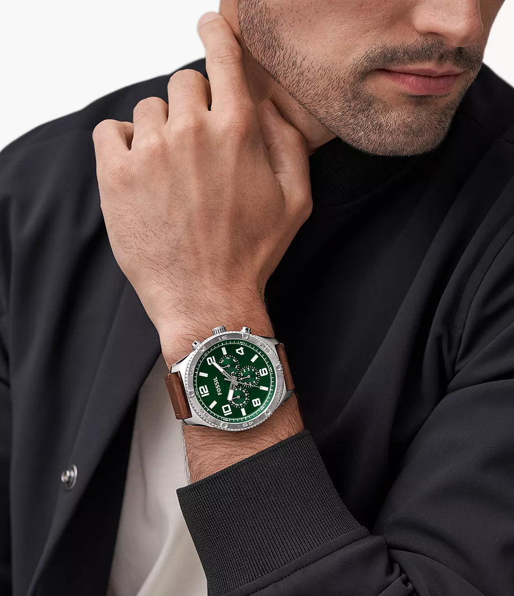 Fossil Brox multifunction watch worn on man's wrist with green dial visible