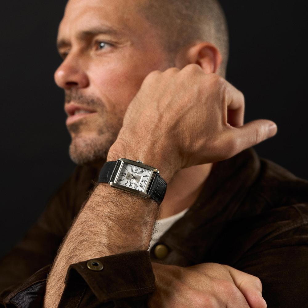 Fossil Carraway watch worn on man's wrist showing rectangular case and black leather strap in profile