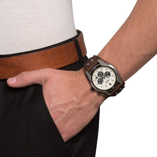 Fossil Coachman CH2890 chronograph watch worn on wrist showing white dial and brown strap
