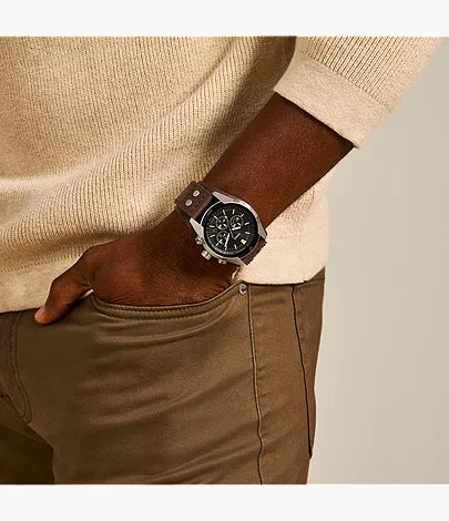Fossil Coachman chronograph watch worn on wrist with beige sweater