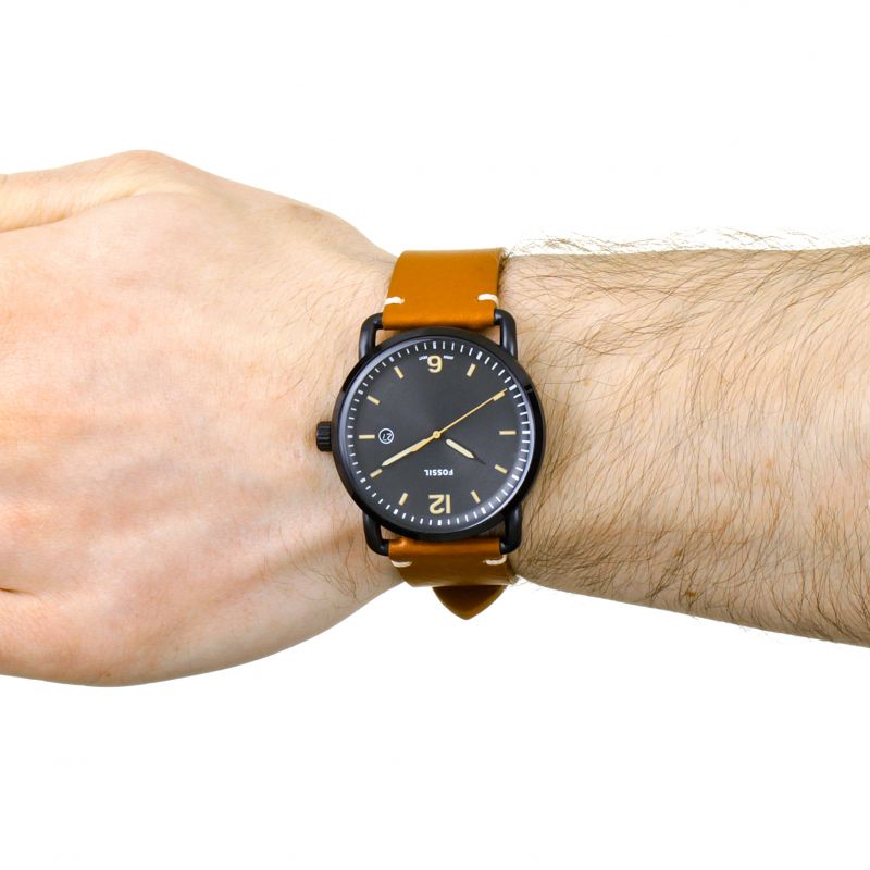Fossil Commuter black dial watch worn on wrist with brown leather strap