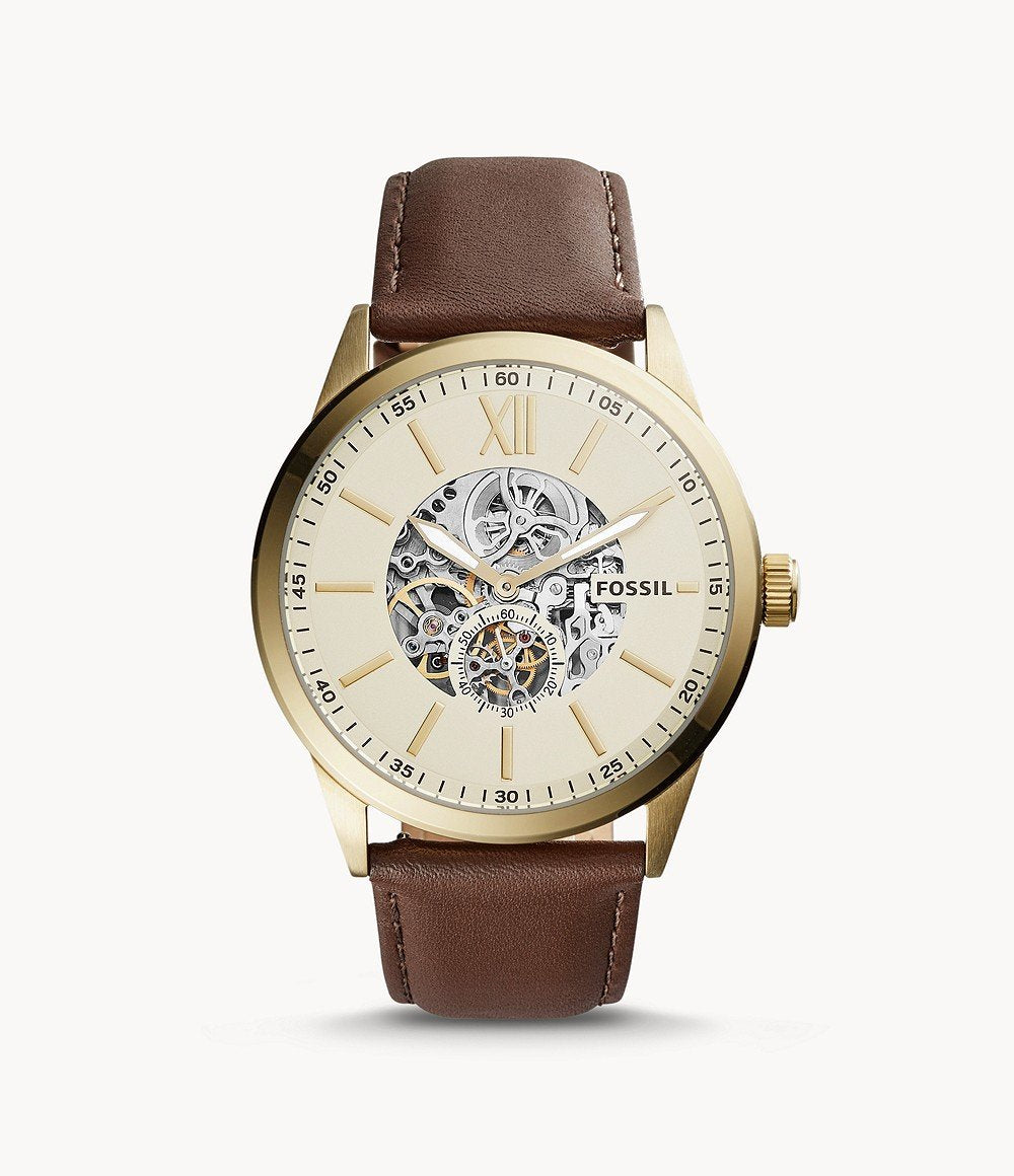 Fossil Flynn watch worn, showing cream dial with exposed skeleton movement and brown strap