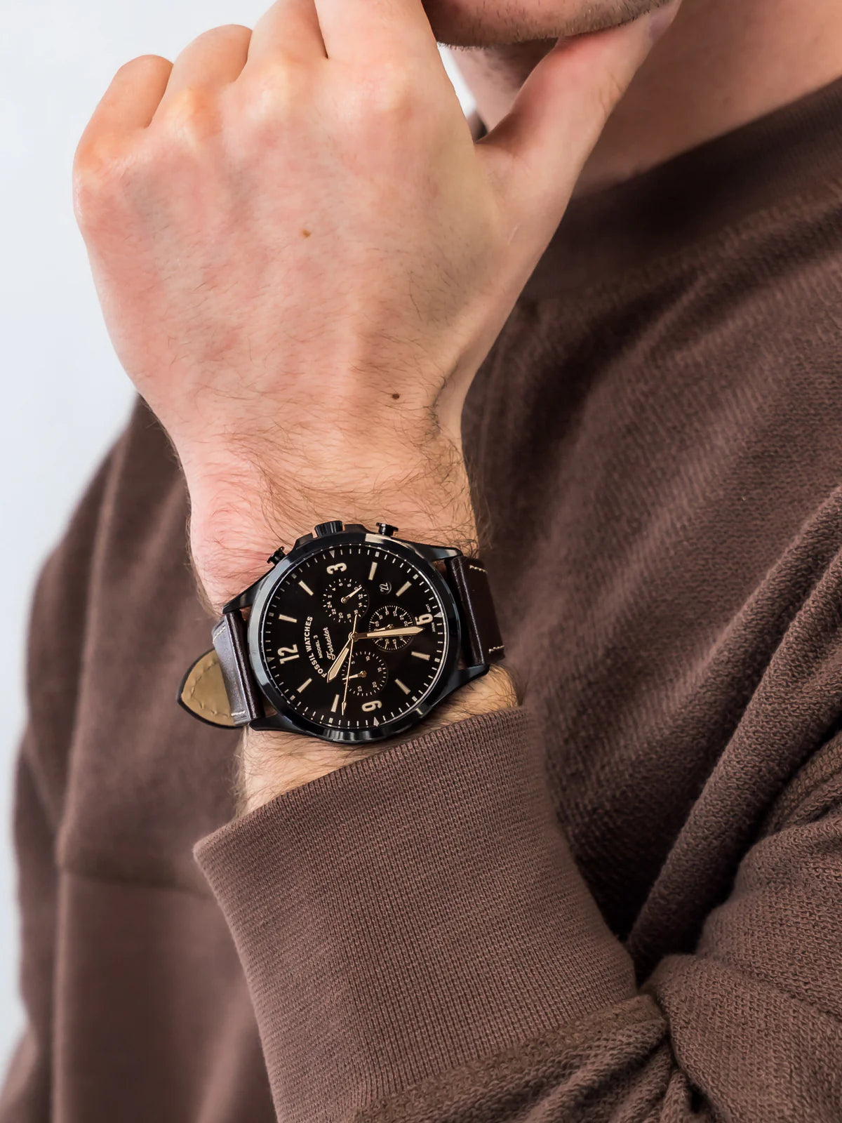 Fossil Forrester chronograph watch worn on wrist, black dial with rose gold accents and brown leather strap