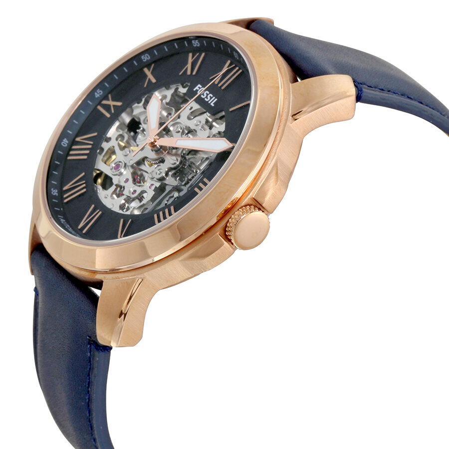 Side angle view of Fossil Grant watch showing rose gold case, navy skeleton dial with Roman numerals, and navy strap