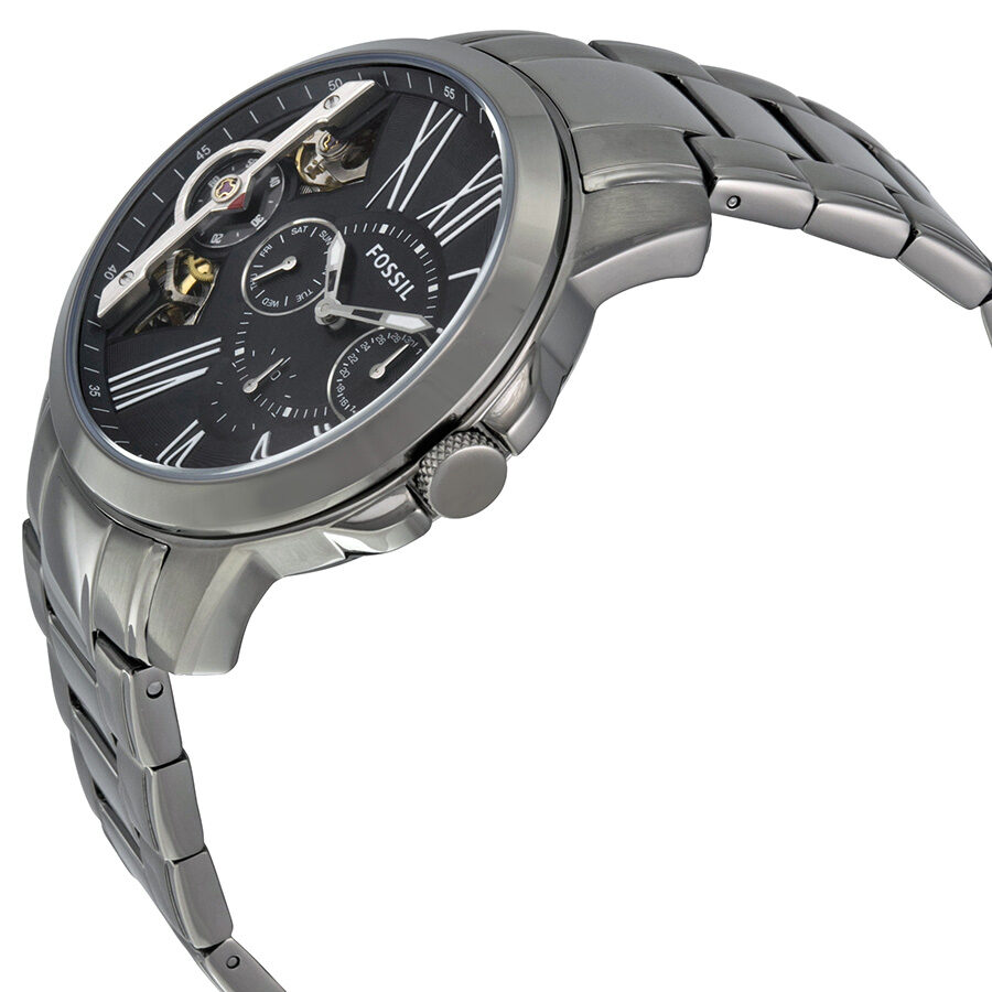 Fossil Grant men's watch from side angle showing stainless steel bracelet and black dial with visible movement