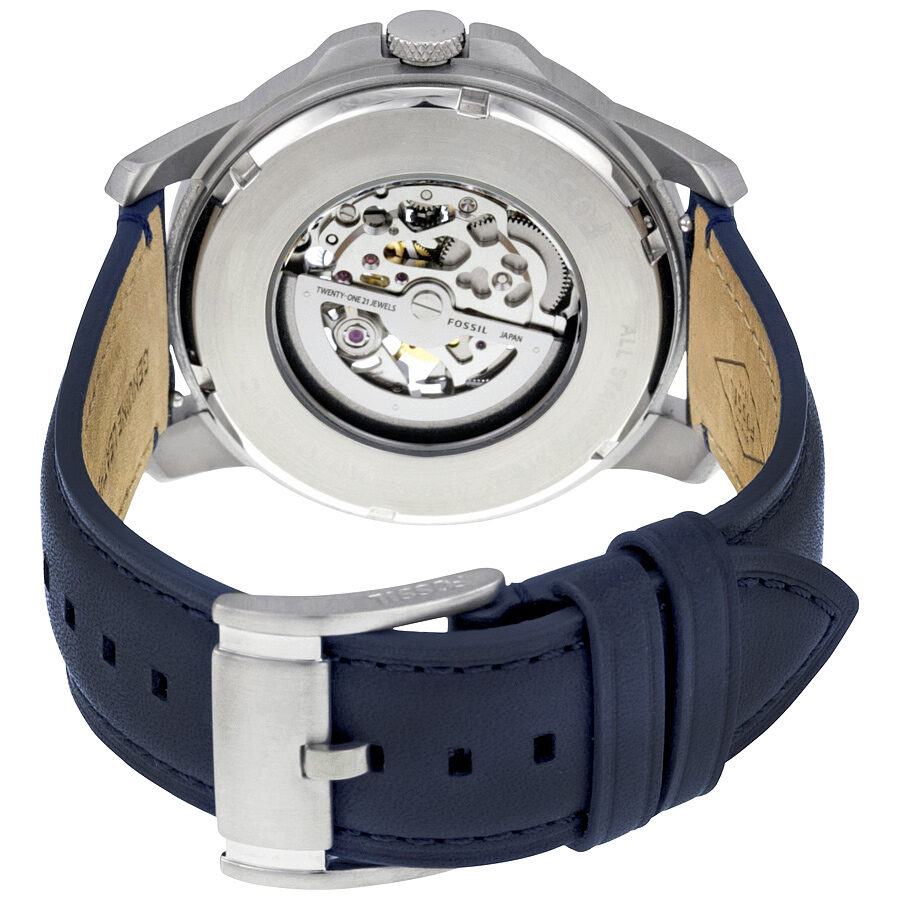 Fossil Grant caseback showing visible automatic movement and navy leather strap with tan interior